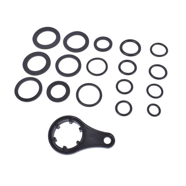 Set of black mechanical washers and a larger component on a white background