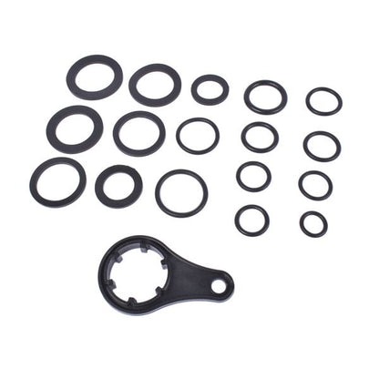 Set of black mechanical washers and a larger component on a white background
