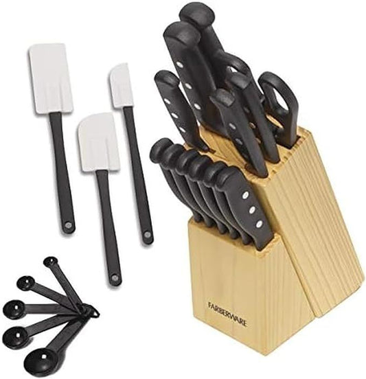 Set of knives in a wooden block with spatulas and measuring spoons on a white background